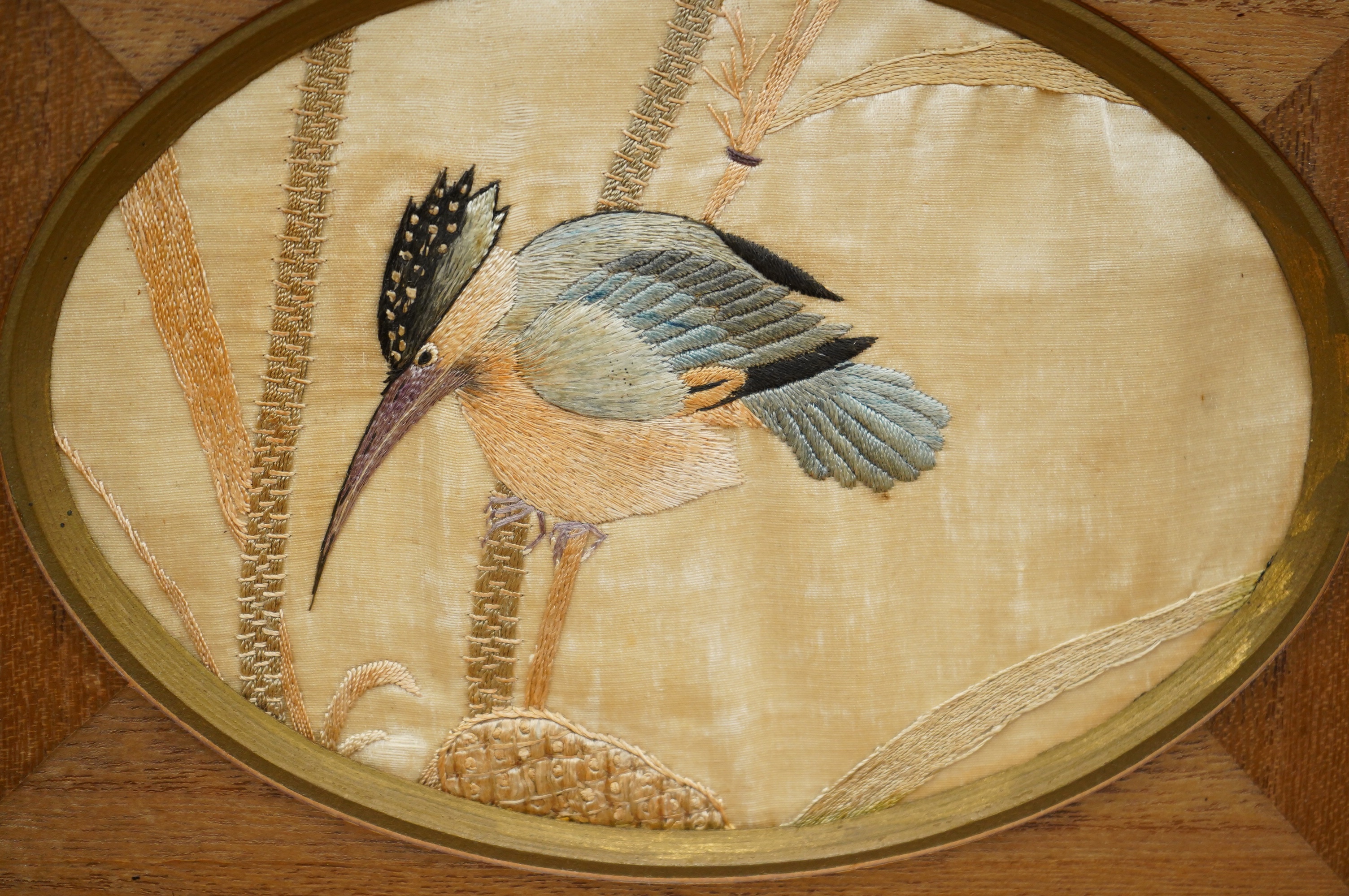 A pair of framed early 20th century Japanese oval silk embroideries of Kingfishers, embroidered on cream silk in pastel shades of silk thread, in a variety of stitches, various parts of each bird slightly couched giving